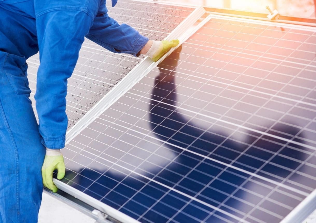 A person working on solar panels with gloves.