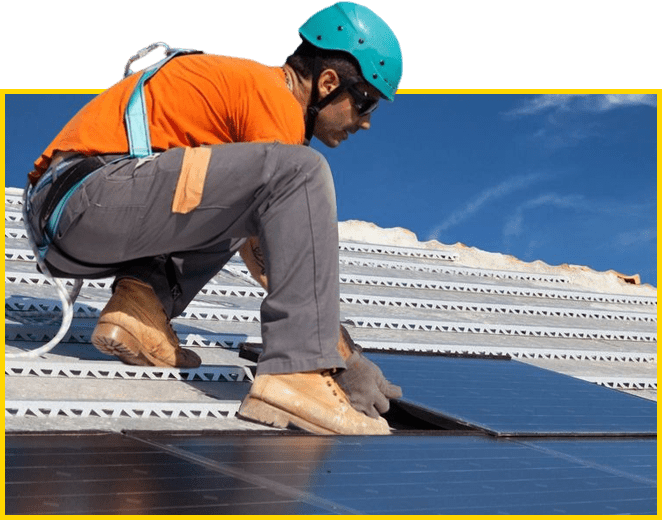 A man in an orange shirt and helmet working on the roof of a building.